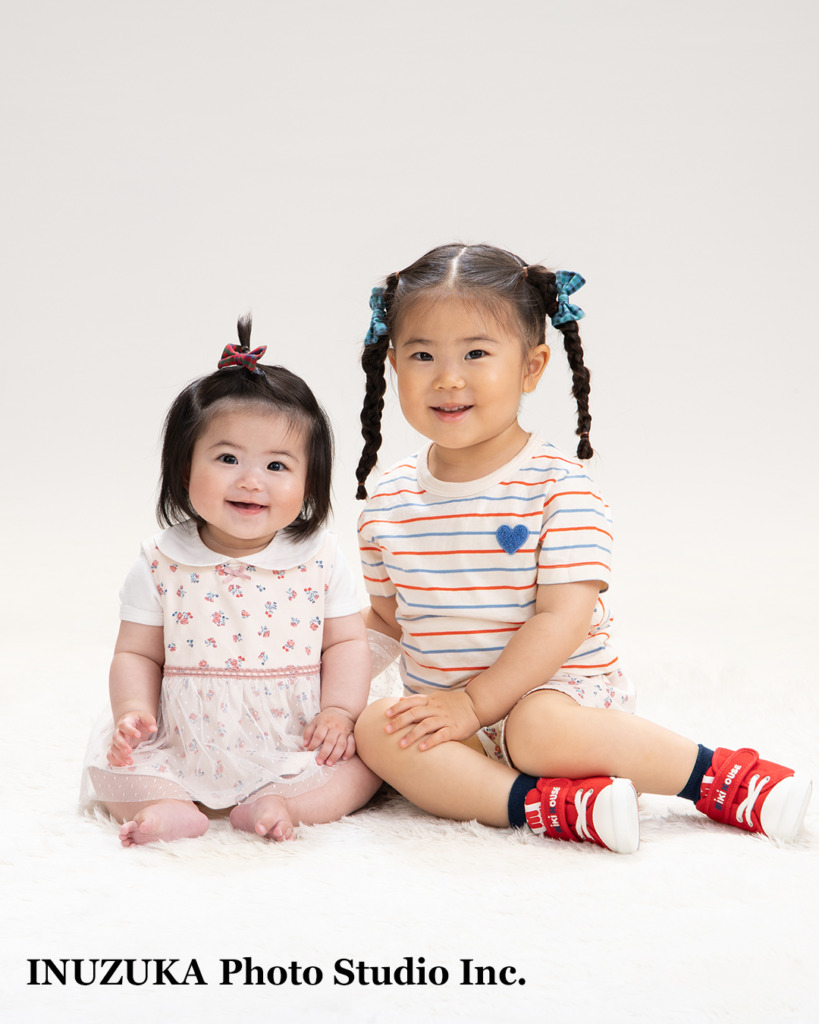 いぬづか写真室で撮影した一歳記念の自然な姉妹の笑顔